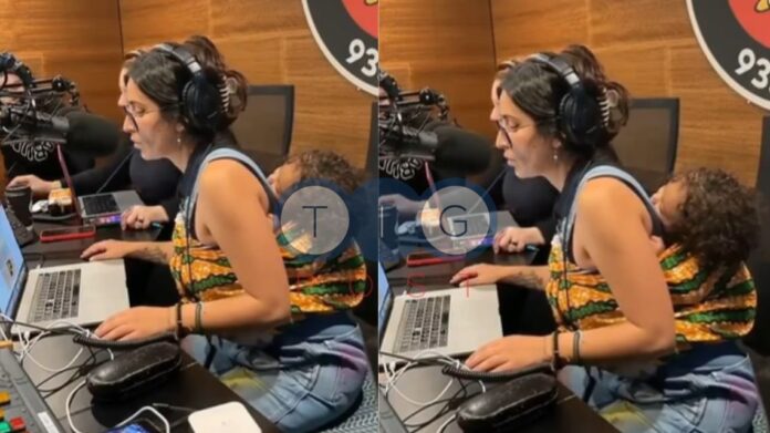 Watch an Australian radio host work whilst carrying baby at her back